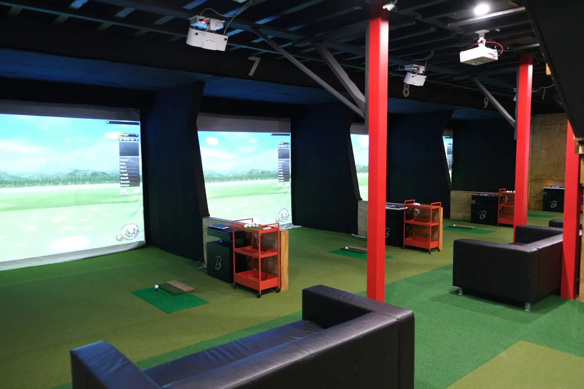 Open simulator bays with seating behind the hitting areas